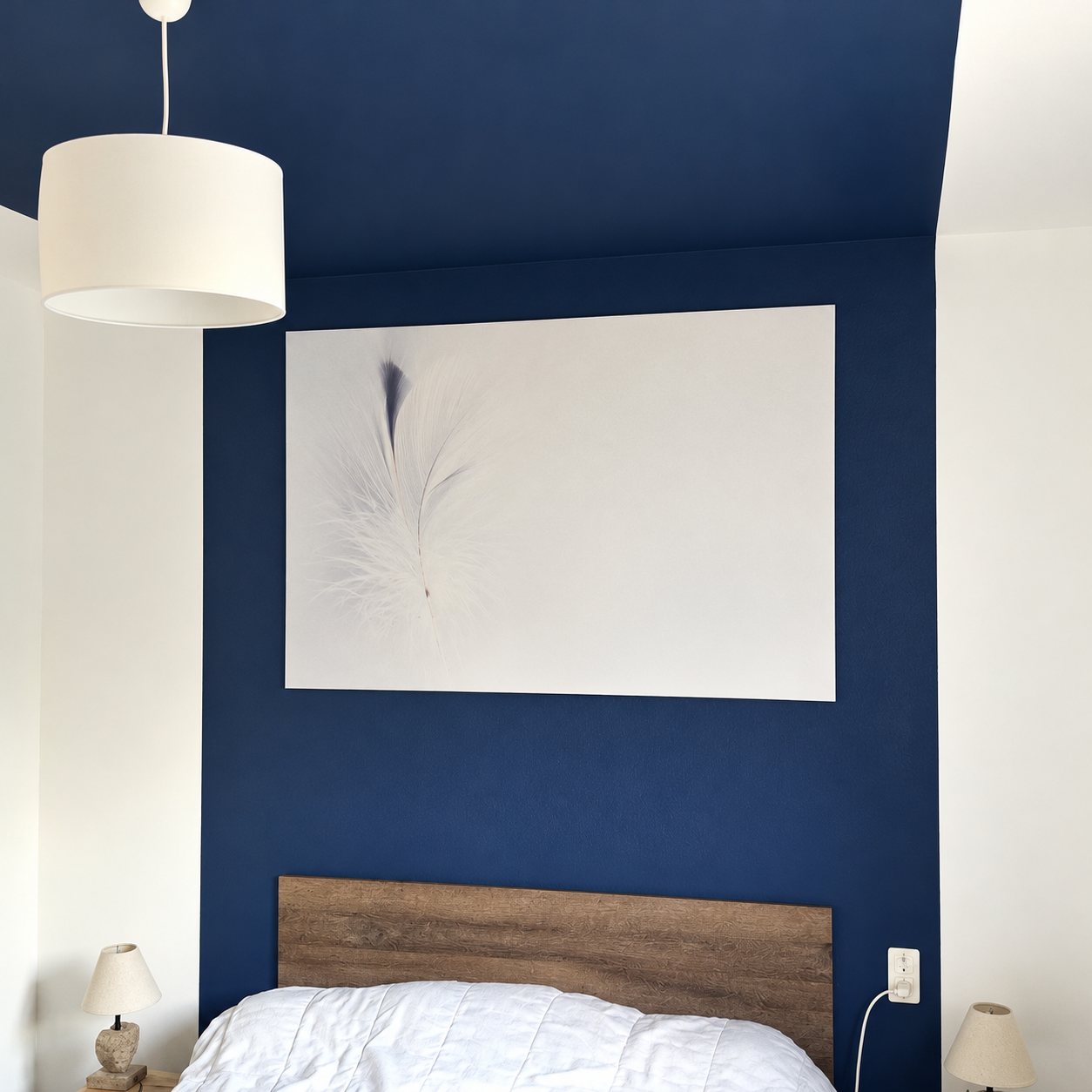 Chambre aux murs bleu marine avec tête de lit en bois