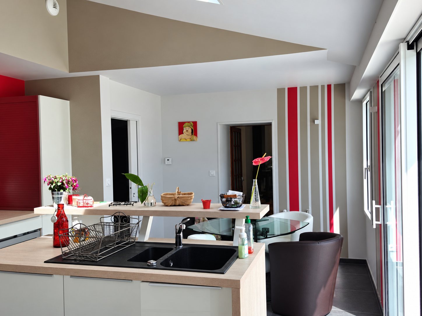 Cuisine ouverte moderne aux murs rayés rouge et beige, repeints par Peinture de la Côte
