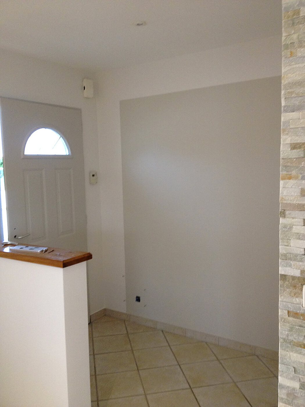 Entrée rénovée avec mur gris, carrelage et parement en pierre