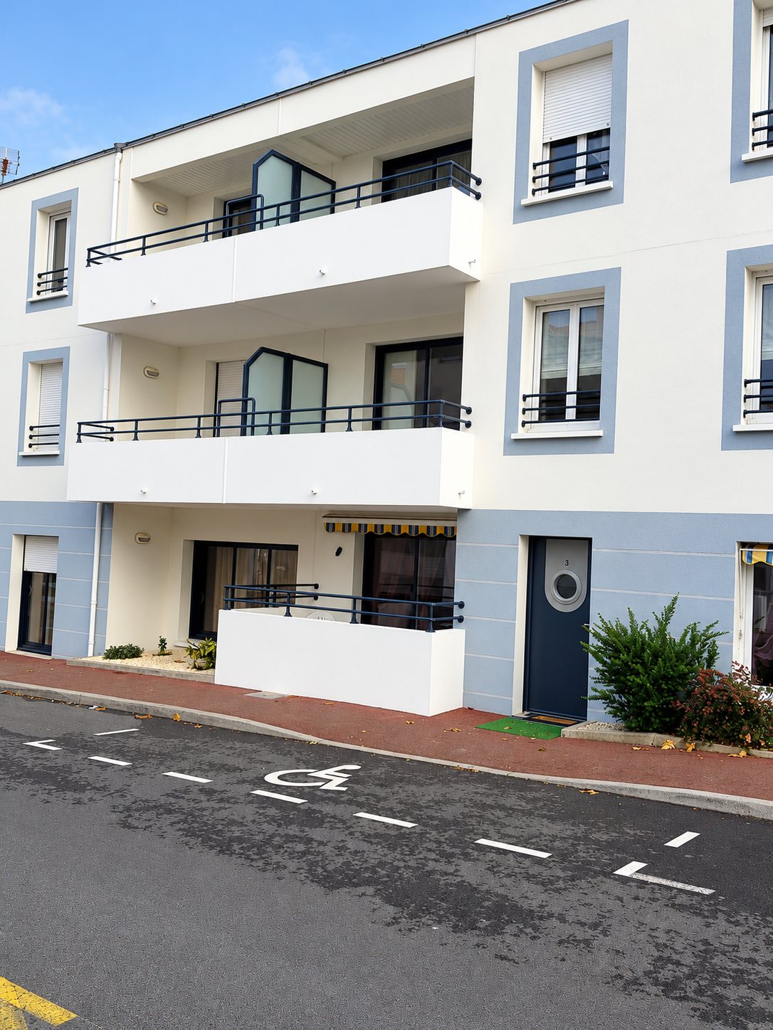 Façade d’immeuble rénovée avec balcons repeints en bleu