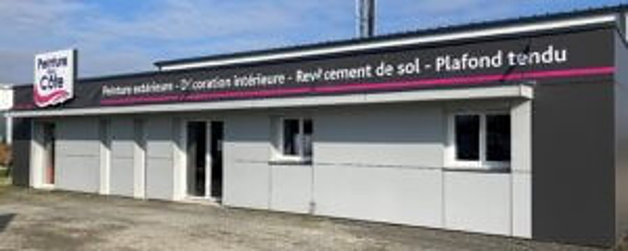 Bâtiment de plain-pied gris clair et blanc portant une enseigne de peintre et un bandeau mauve listant ses services.